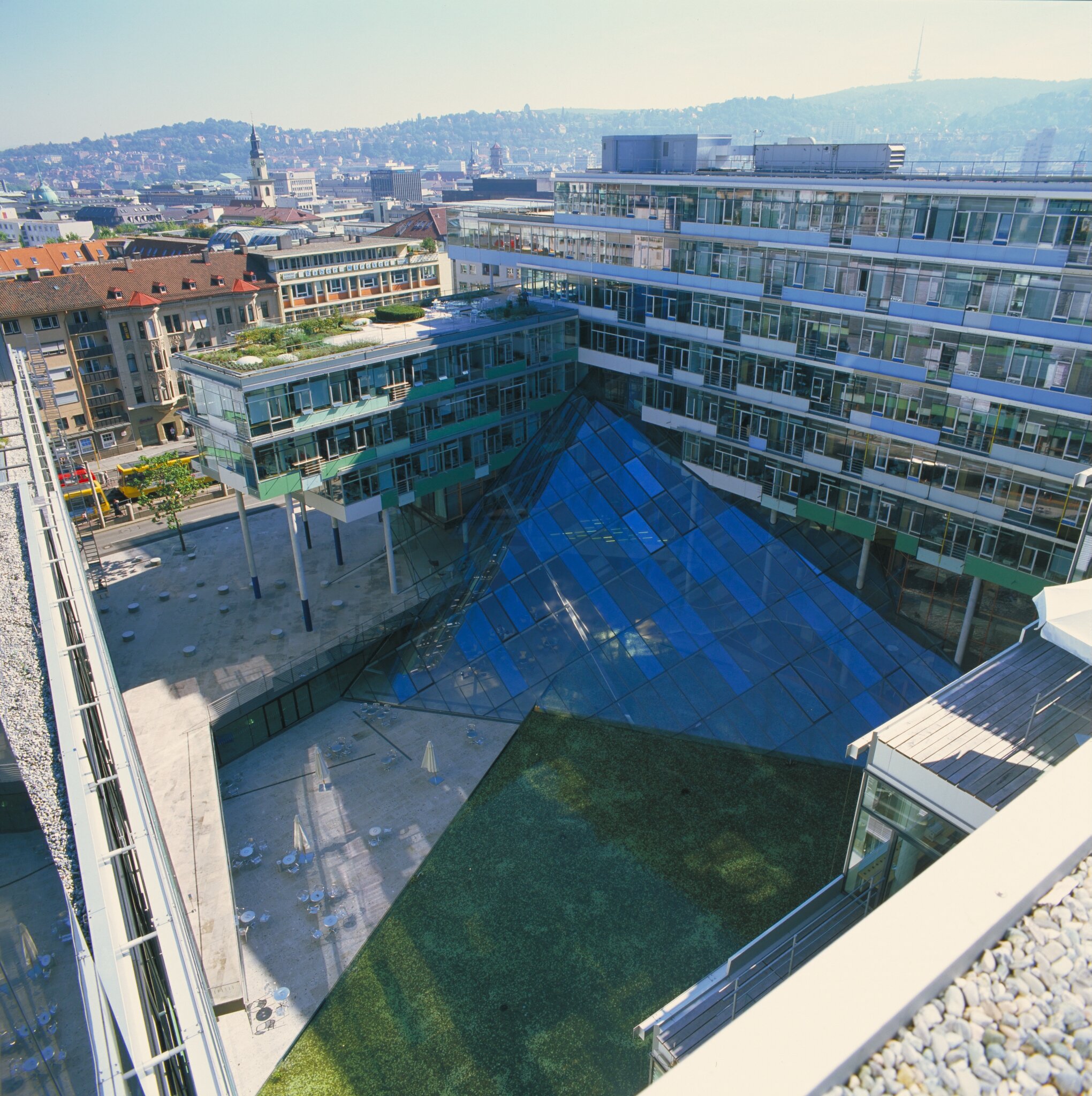 Project by Behnisch Architekturbuero, Landesgirokasse am Bollwerk. The building complex with glass pyramid roof over a courtyard, surrounded by offices and city skyline in the background.