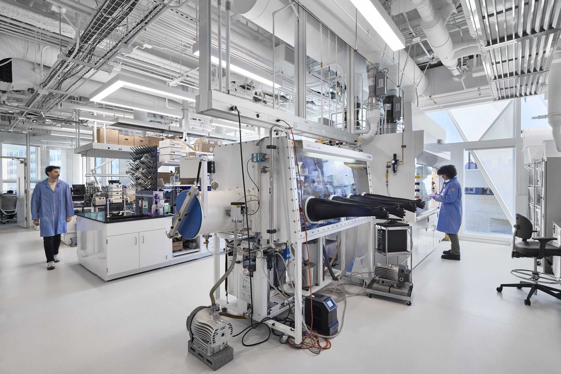 Project by Behnisch Architekturbuero, The Vagelos Laboratory for Energy Science & Technology, University of Pennsylvania. Laboratory interior with people working on the equipment and staying in the laboratory.