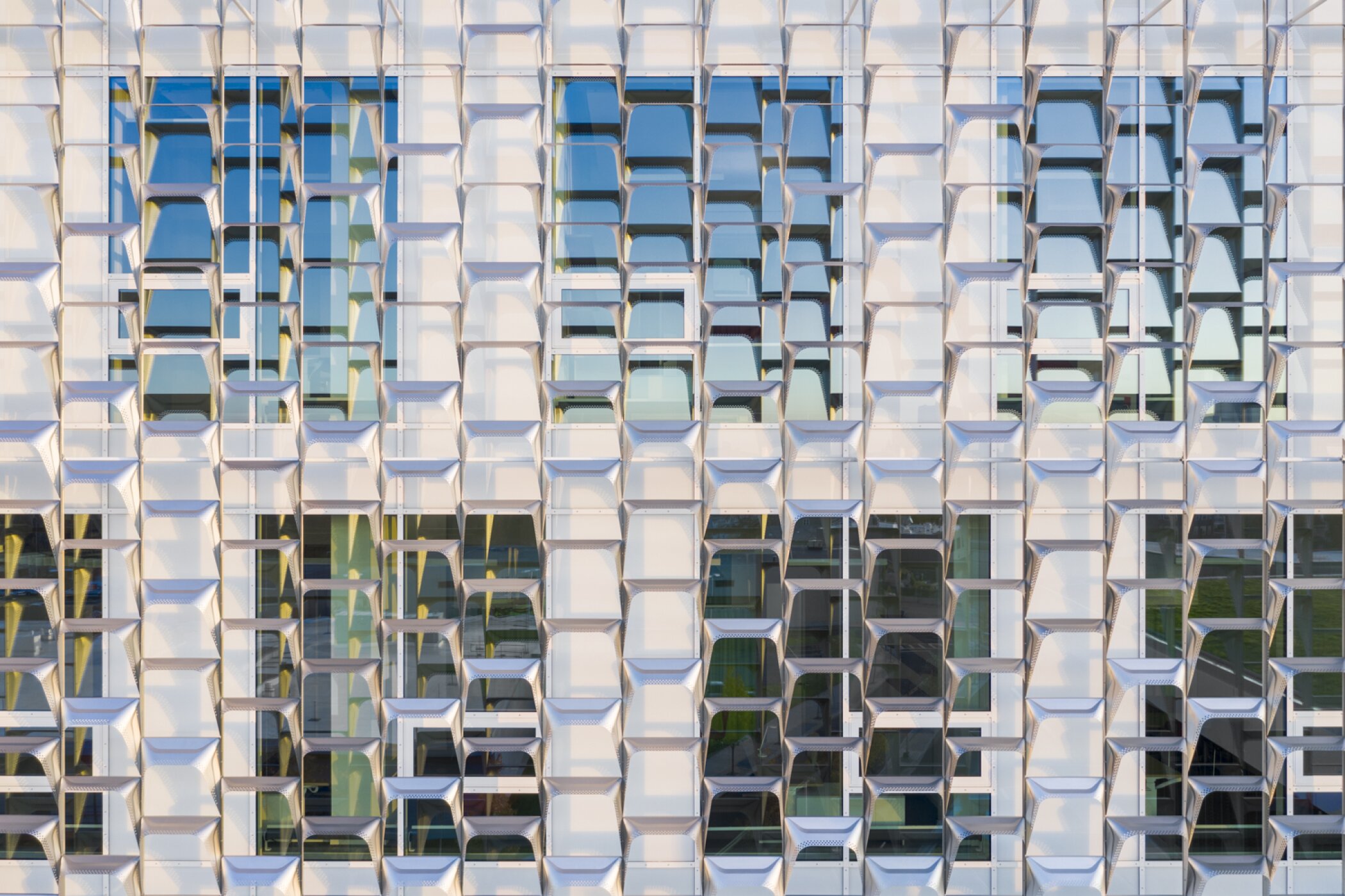 Project by Behnisch Architekturbuero, Harvard University Science and Engineering Complex (SEC). Close-up of the facade with repeating geometric panels and windows, creating a textured grid pattern with light and shadow.